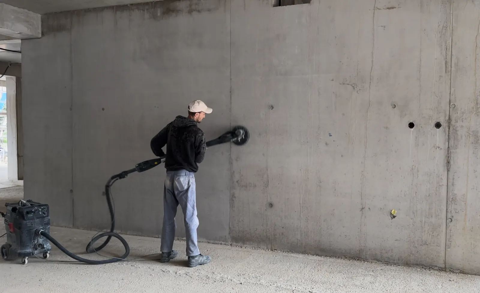 Mechanische Reinigung von Sichtbeton mit Langhalsschleifer und Absaugung